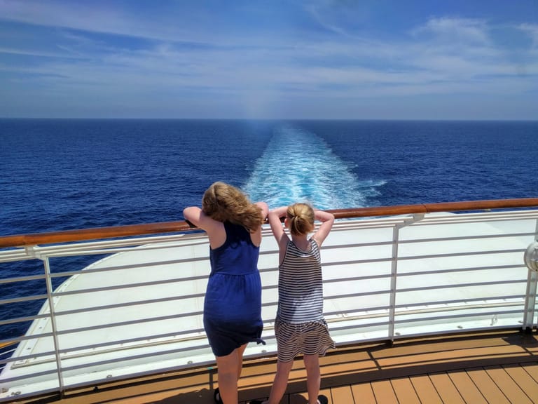 Two girls looking out to sea at the back of a Disney Cruise