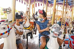 Children with Masks Riding on Prince Charming Carousel at Walt Disney World