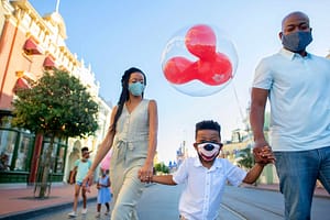 A family wearing medical masks at Disney's Magic Kingdom