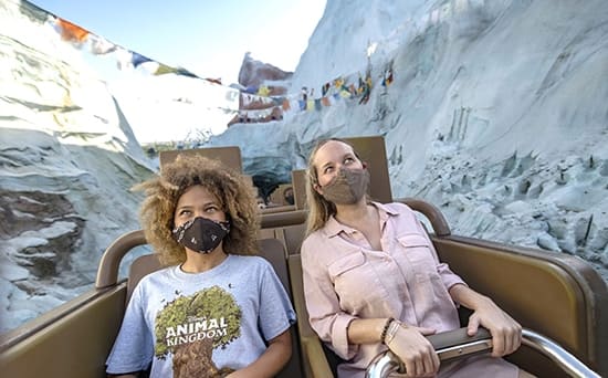 Two ladies with masks on Everest Expedition rollercoaster at Disney's Animal Kingdom Theme Park